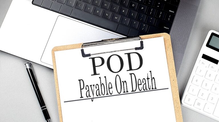 POD word on clipboard on a laptop with calculator and pen